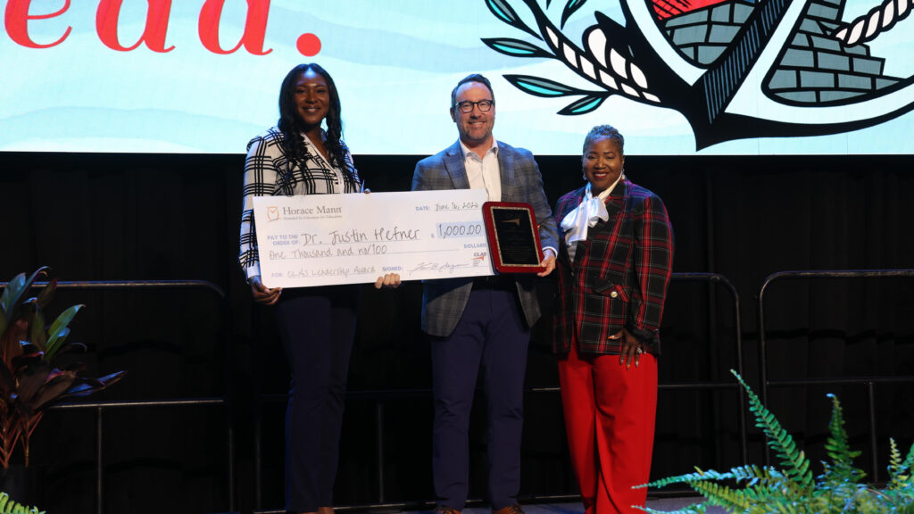 Dr. Justin Hefner holds the CLAS Leadership Award plaque alongside Horace Mann representative Yahrasiel Colbert and CLAS President Dr. Regina Thompson, with a ceremonial $1,000 check.